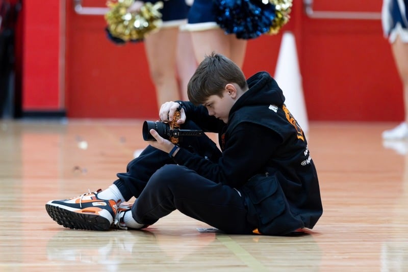 Mac Goolsby shooting courtside at a basketball game